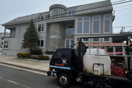 Technician rinsing salt haze from linwood nj storefront windows